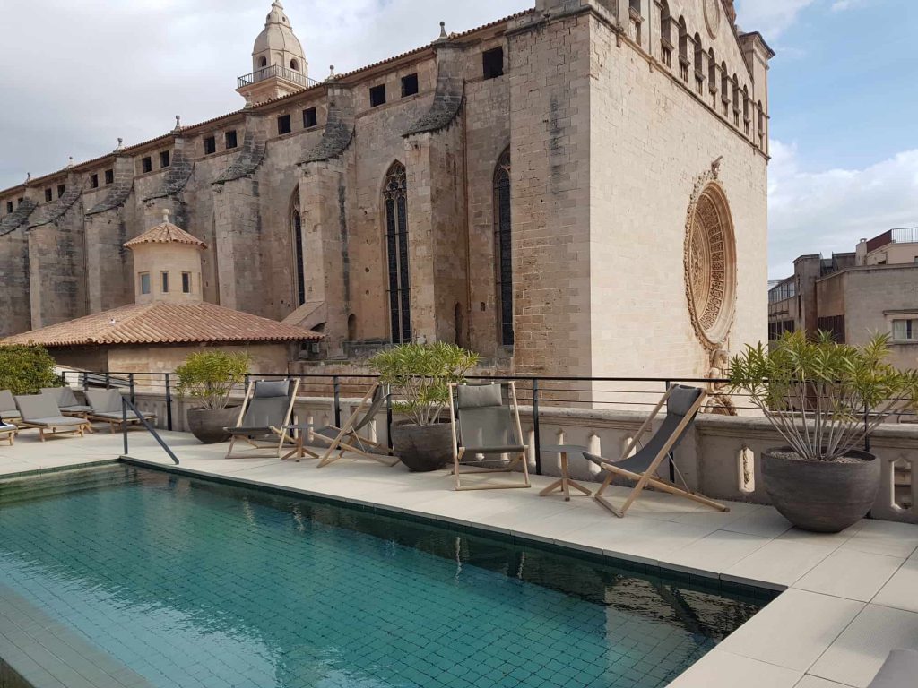Piscina en la azotea del hotel Sant Francesc de Palma, con el ábside y el rosetón de la basílica justo detrás