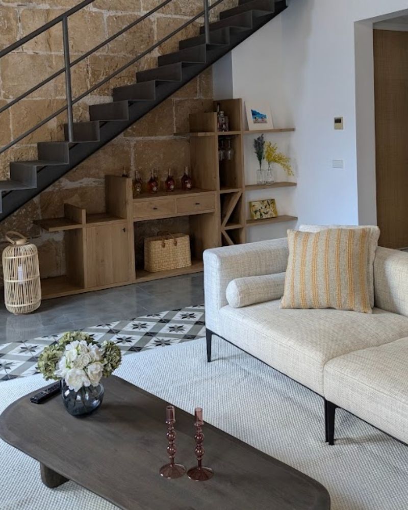 Salón reformado con pared de marés y escalera metálica en el casco antiguo de Palma, Mallorca