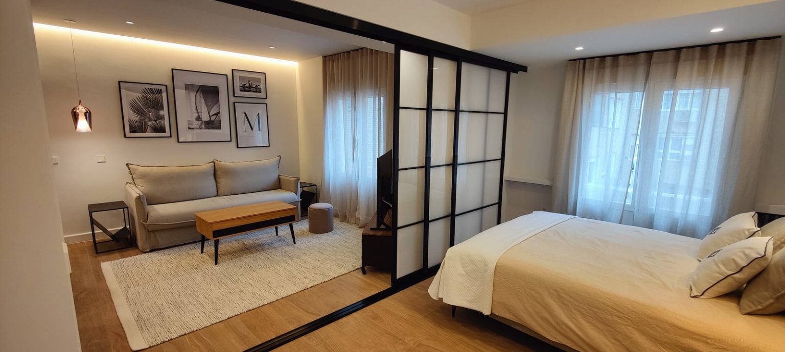 Piso reformado en Madrid con puertas correderas de cristal translúcido que separan dormitorio y salón