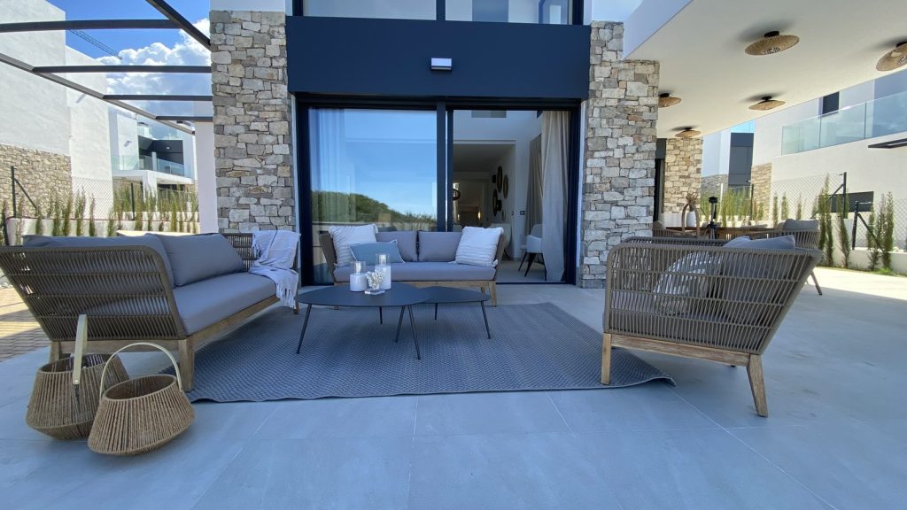 Terraza amueblada en Colònia de Sant Pere, Mallorca, con sofás de cuerda trenzada y fachada de piedra natural