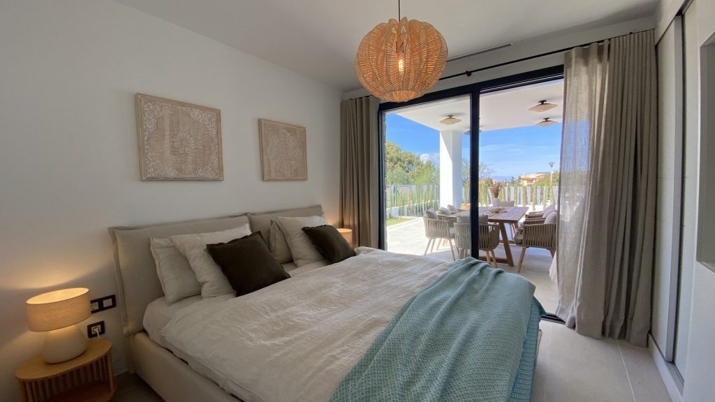 Dormitorio decorado en Colònia de Sant Pere, Mallorca, con manta turquesa y salida directa a la terraza