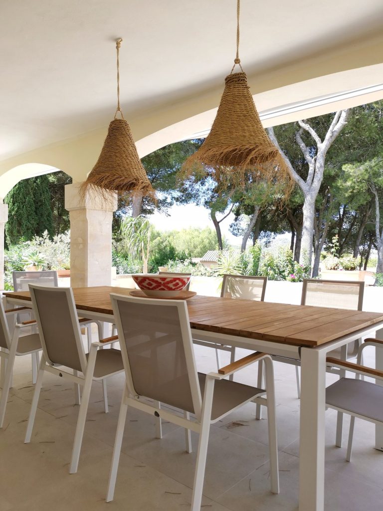 Comedor exterior en la terraza con lamparas de fibra natural en Santa Ponsa