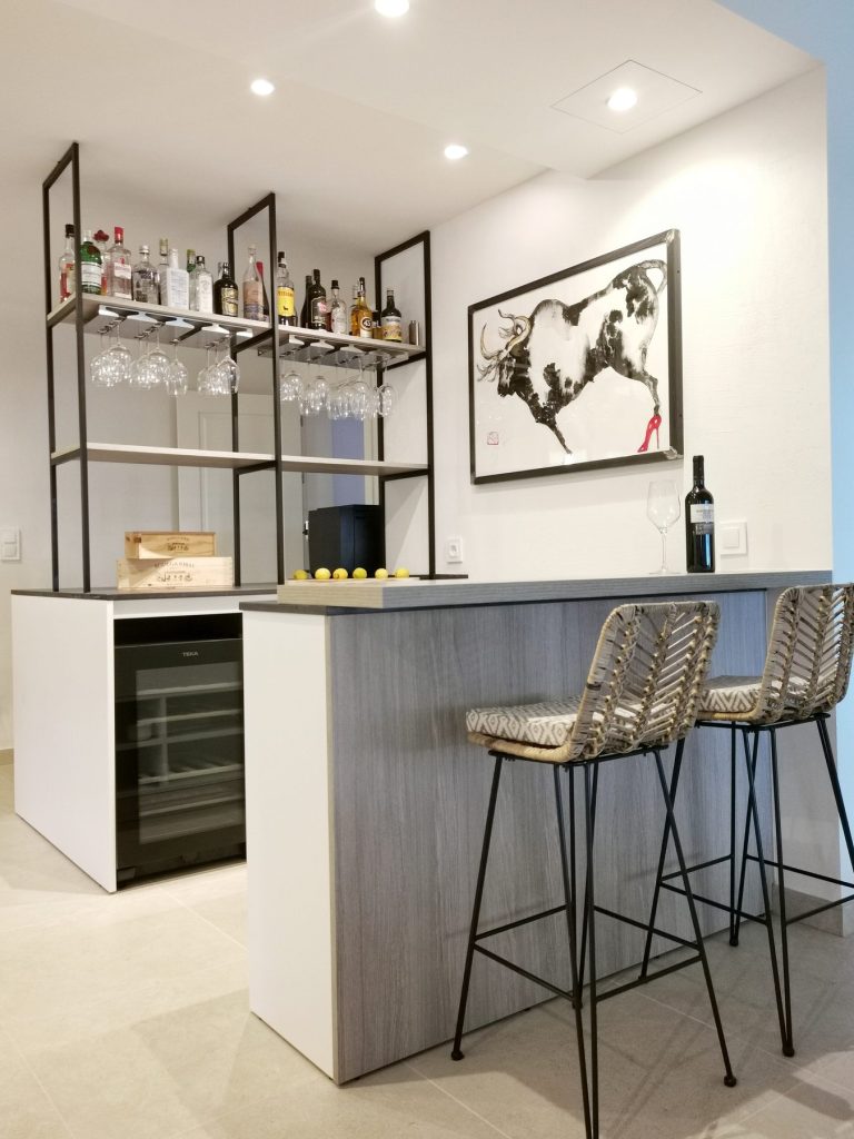 Rincon de bar con estanteria metalica y vinoteca en la reforma de Santa Ponsa