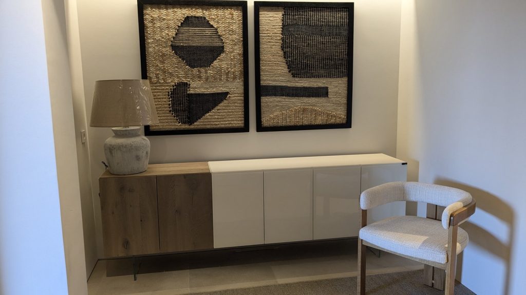 Recibidor decorado en Puerto Andratx, Mallorca, con aparador de roble, tapices enmarcados y silla tapizada