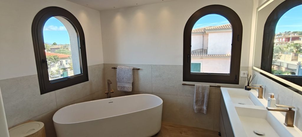 Bano reformado con banera exenta y ventana de arco en Marratxi