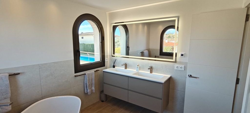 Bano con espejo retroiluminado y doble lavabo en el chalet de Marratxi